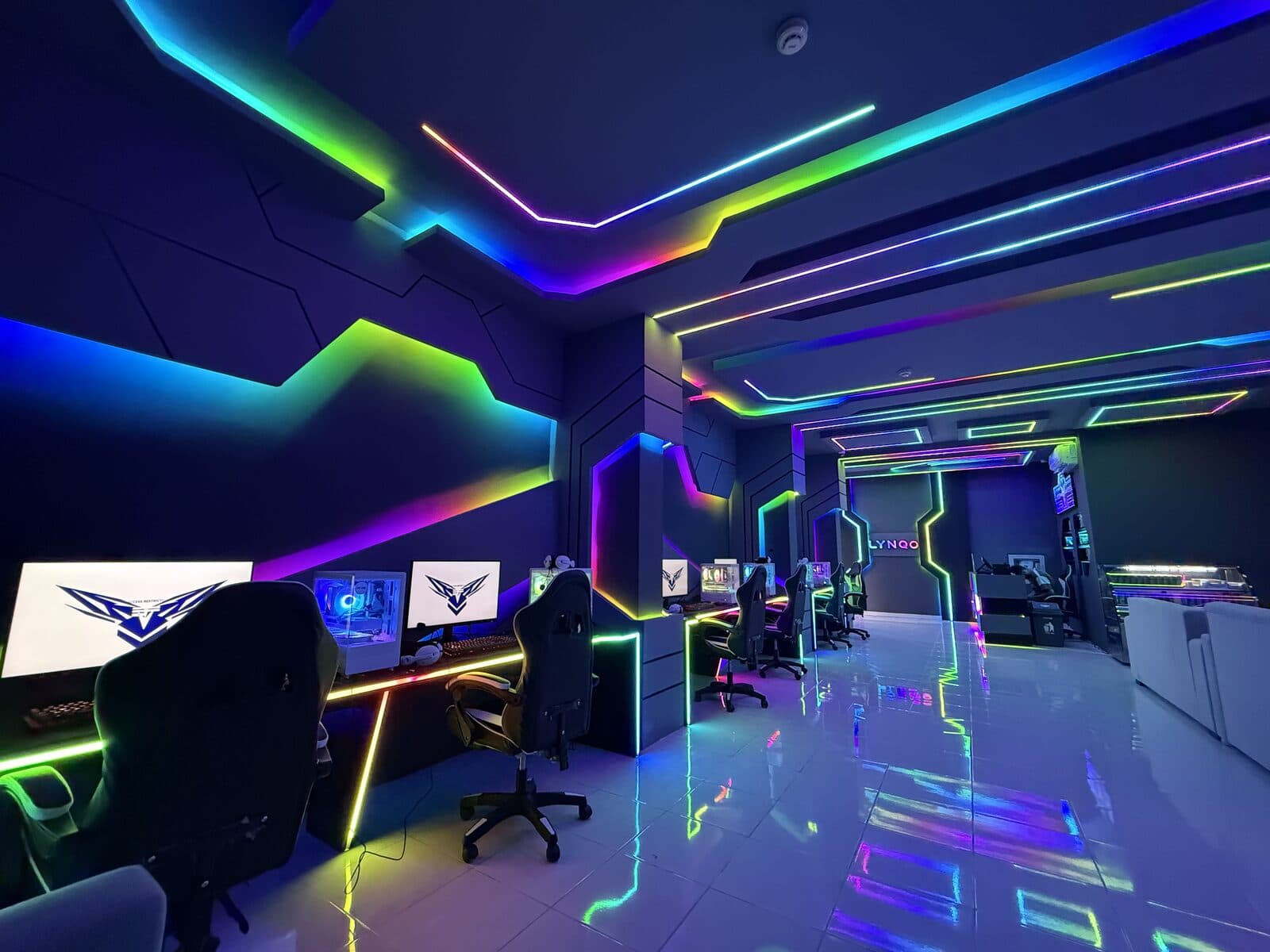 A gaming center lit with neon lines along the ceiling, walls and floor